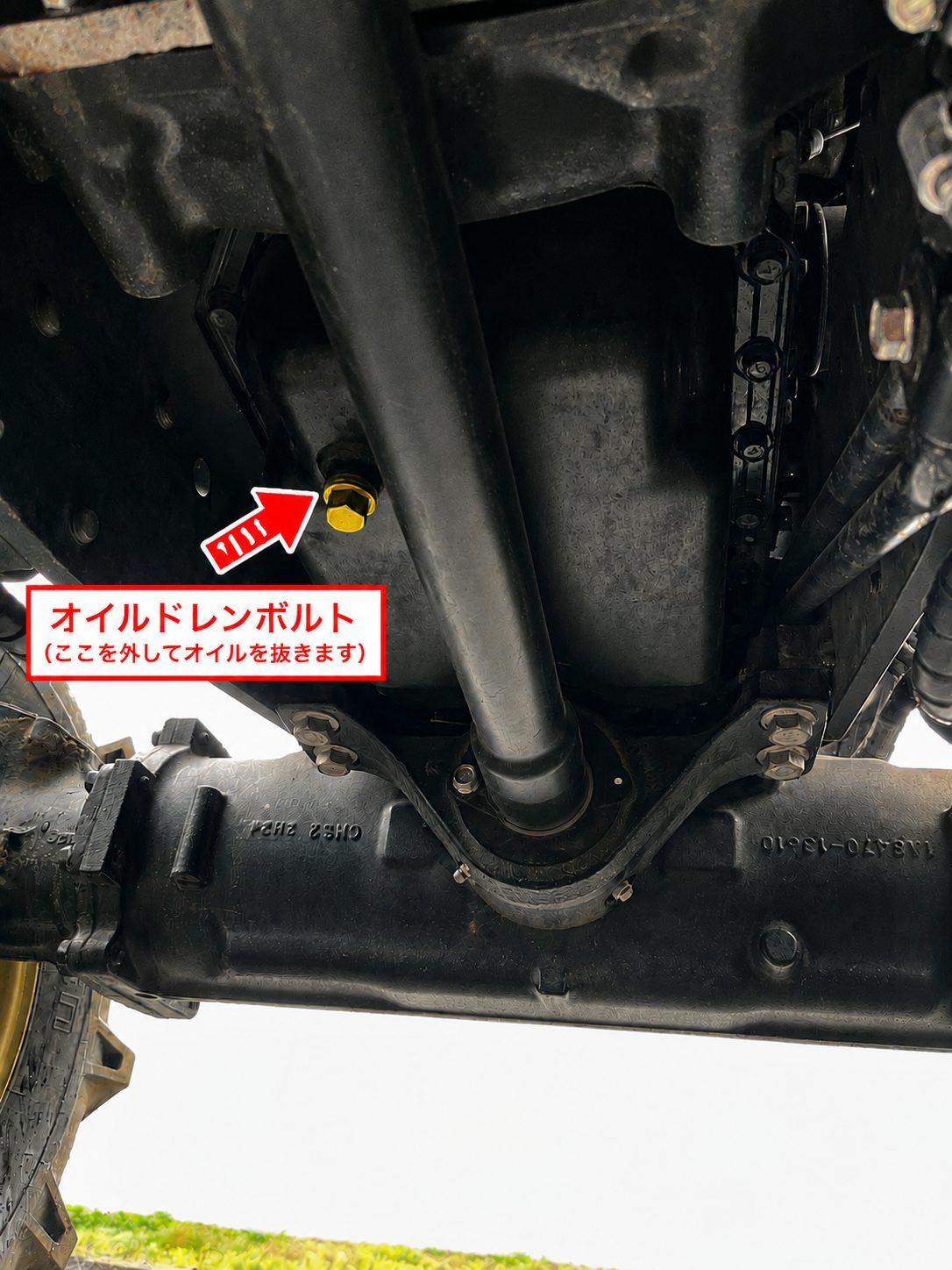 トラクターのオイルドレンボルトの位置。エンジン下部の黄色いボルト